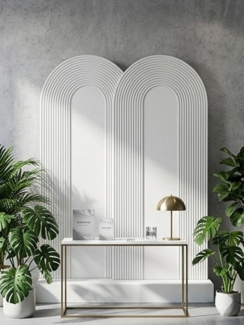Modern double arch white backdrop panel with fluted ribbed texture, set with a minimalist brass console table and indoor green plants for brand activation and event showcase.